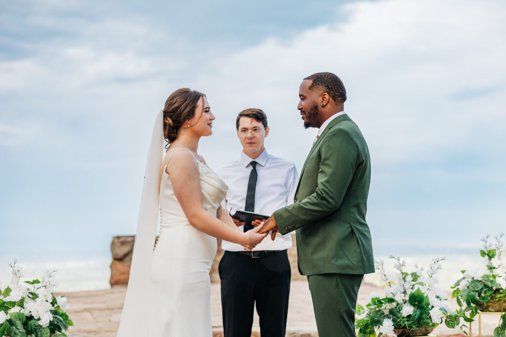 Boulder Wedding Photographer captures bride and groom holding hands and reading vows