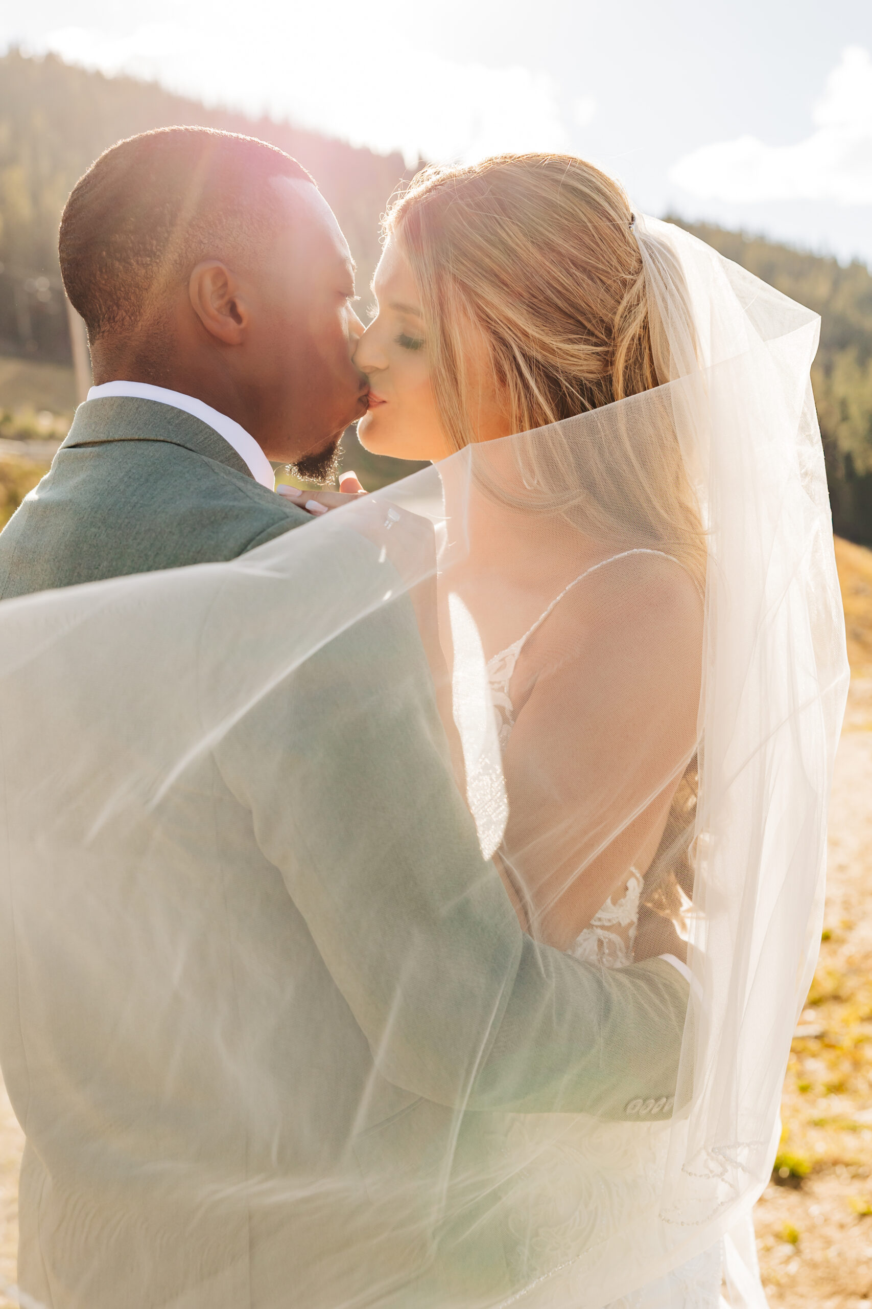 Colorado Elopement Photographer captures bride and groom kissing under veil