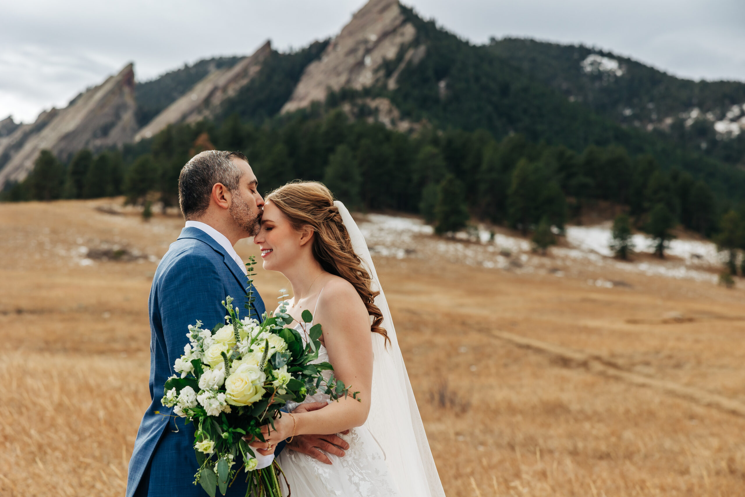 Groom kisses bride's forehead after intimate Colorado wedding