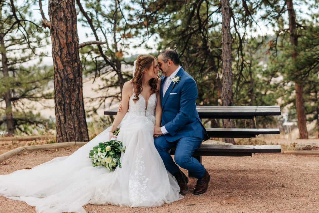 Denver Elopement Photographer capture bride and groom sitting on bench after intimate colorado wedding