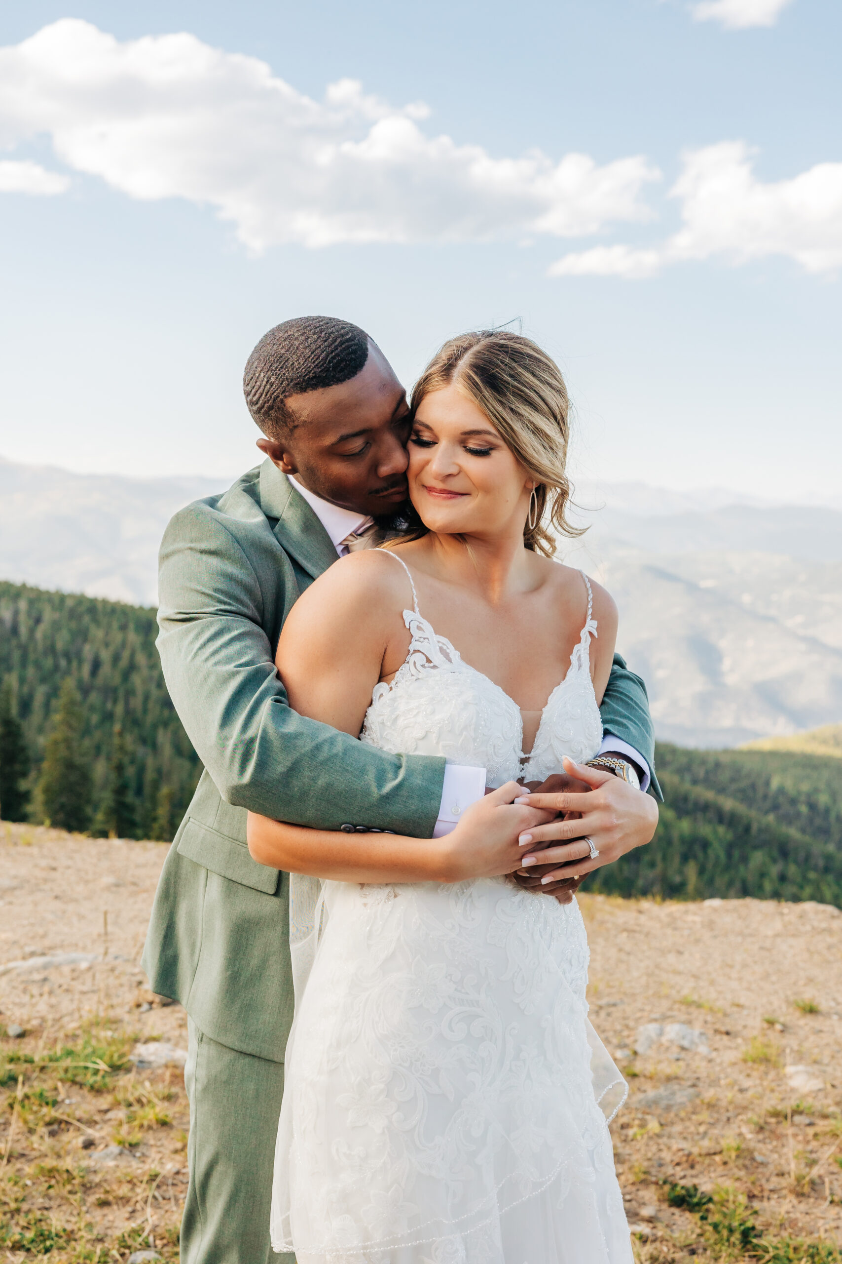 Groom embraces his bride in a tender moment during golden hour, captured as part of their Colorado wedding photos.