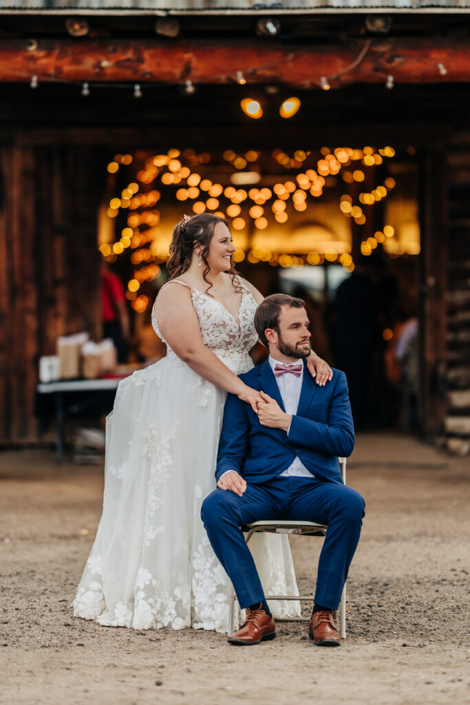 Colorado Wedding Photographer captures groom sitting in chair and bride holding his hand