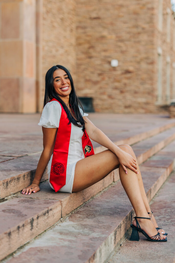 Colorado Senior Photographer captures young gal sitting on stairs wearing red robes