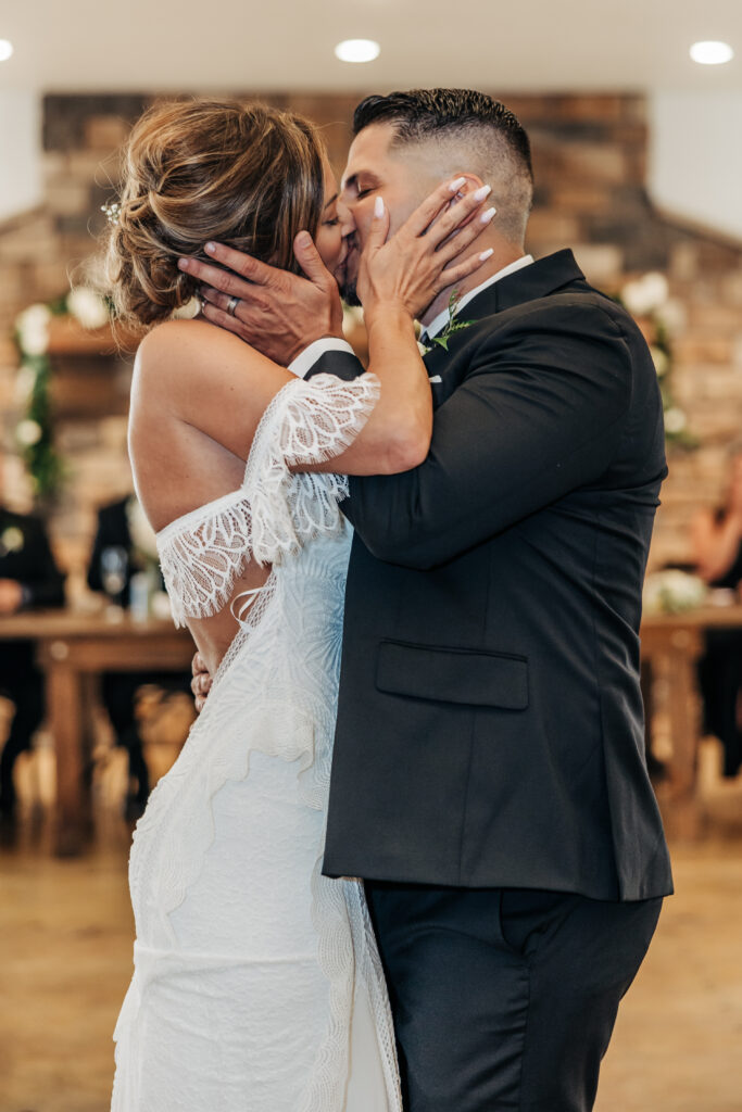 Boulder wedding photographer captures bride and groom kissing during first dance at reception