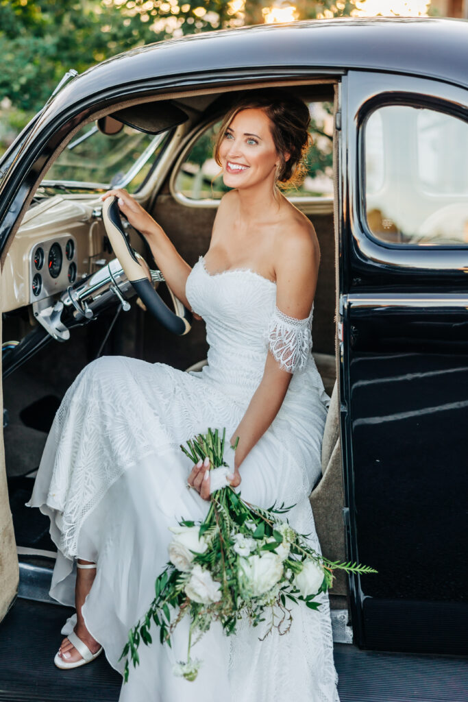 Boulder wedding photographer captures bride sitting in driver's seat holding bouquet