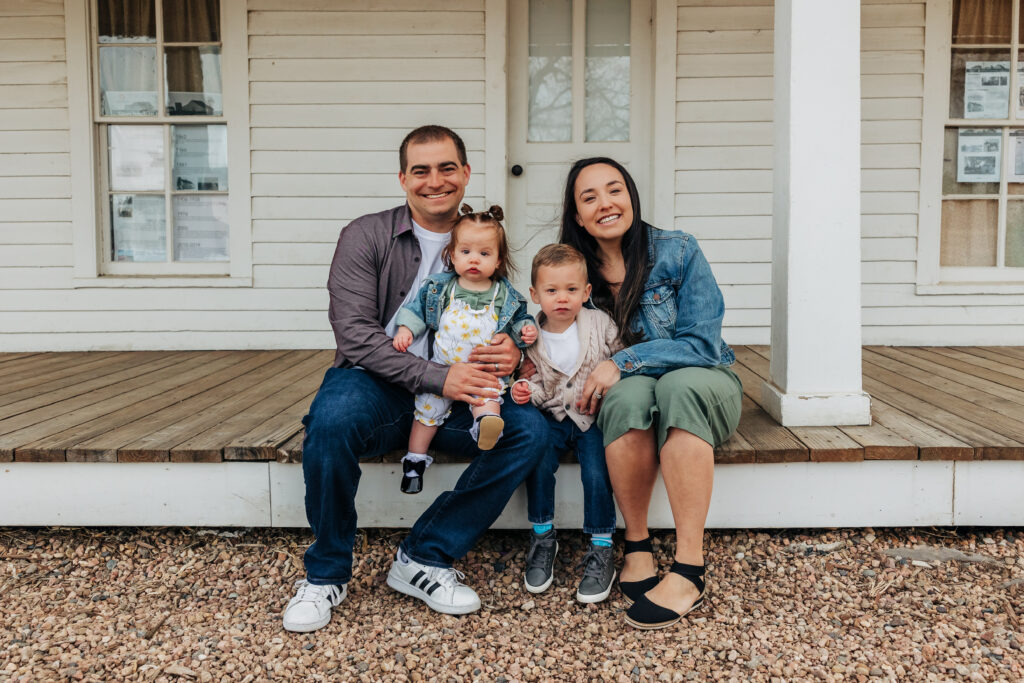 Denver family photographer captures family sitting on porch during outdoor family photos