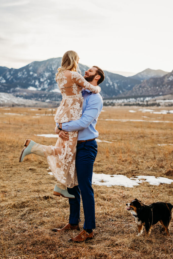 Denver wedding photographer captures man lifting woman in air while puppy runs around