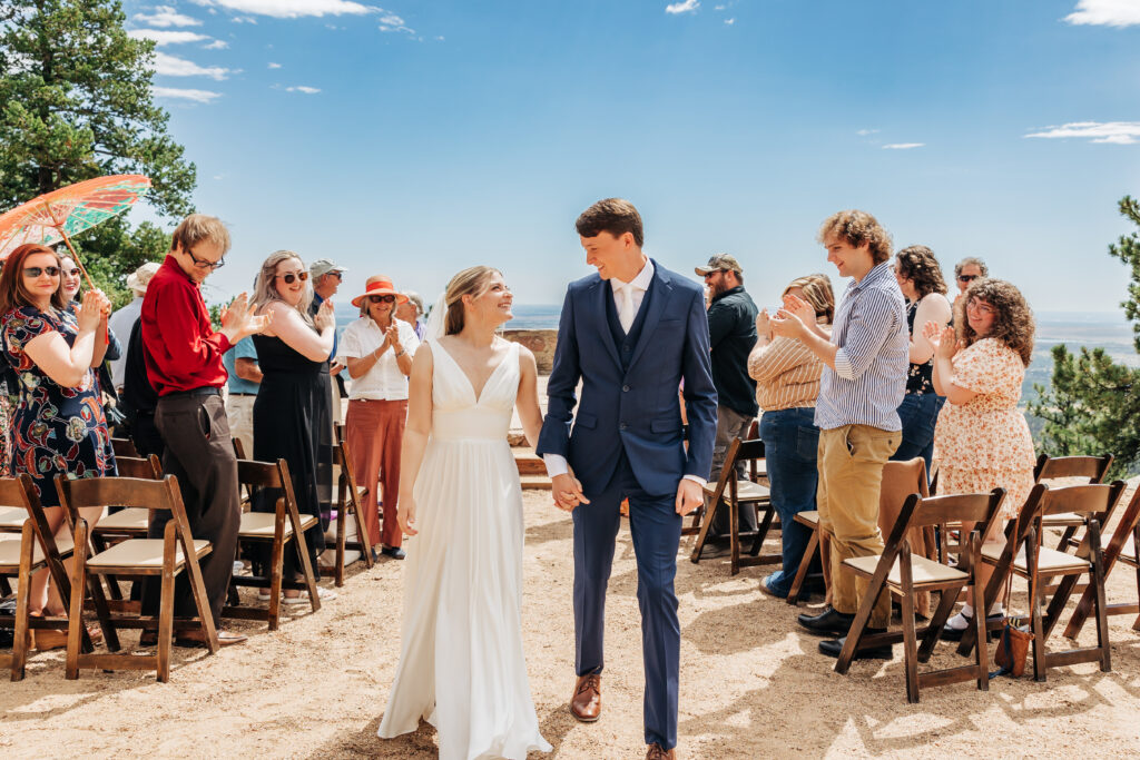 Boulder Wedding Photographer captures bride and groom walking hand in hand after intimate wedding ceremony