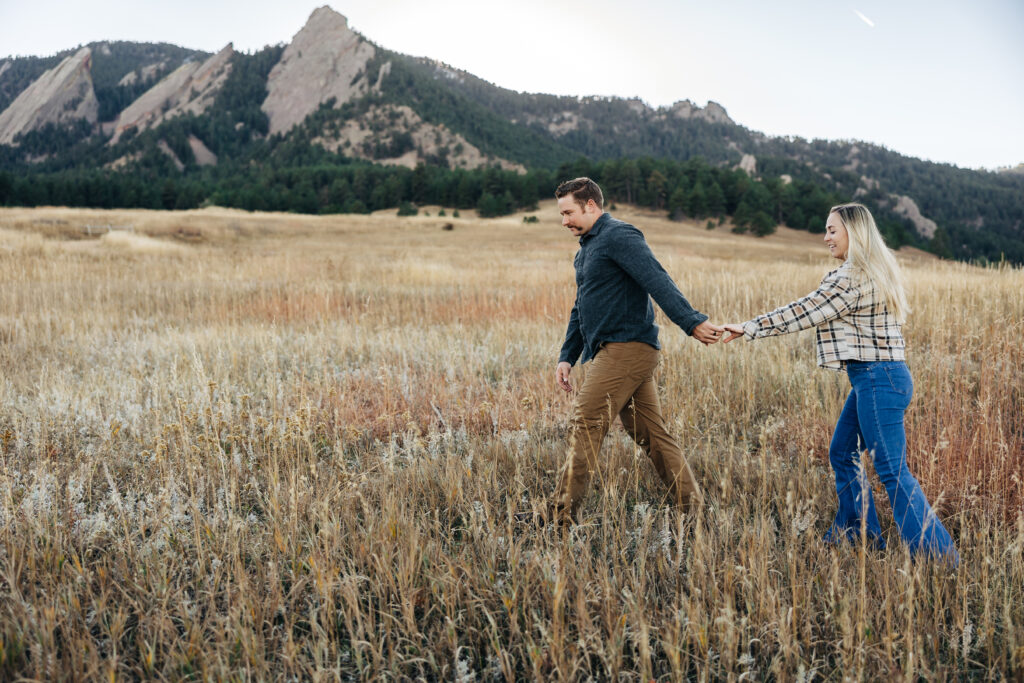 Denver wedding photographer captures man leading woman through grass