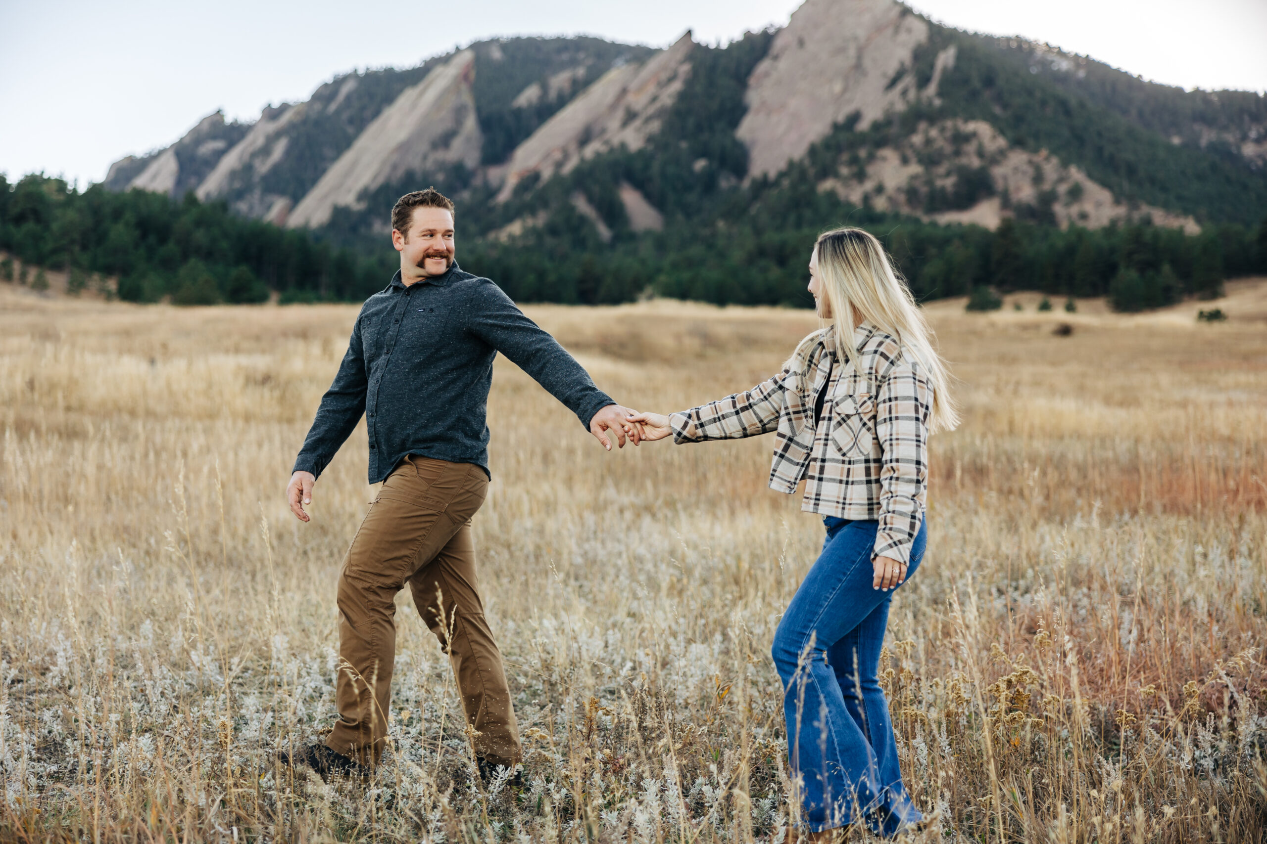 Denver wedding photographer captures man and woman walking hand in hand during engagement photos