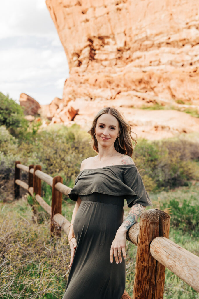 Denver maternity photographer captures woman wearing green maternity dress