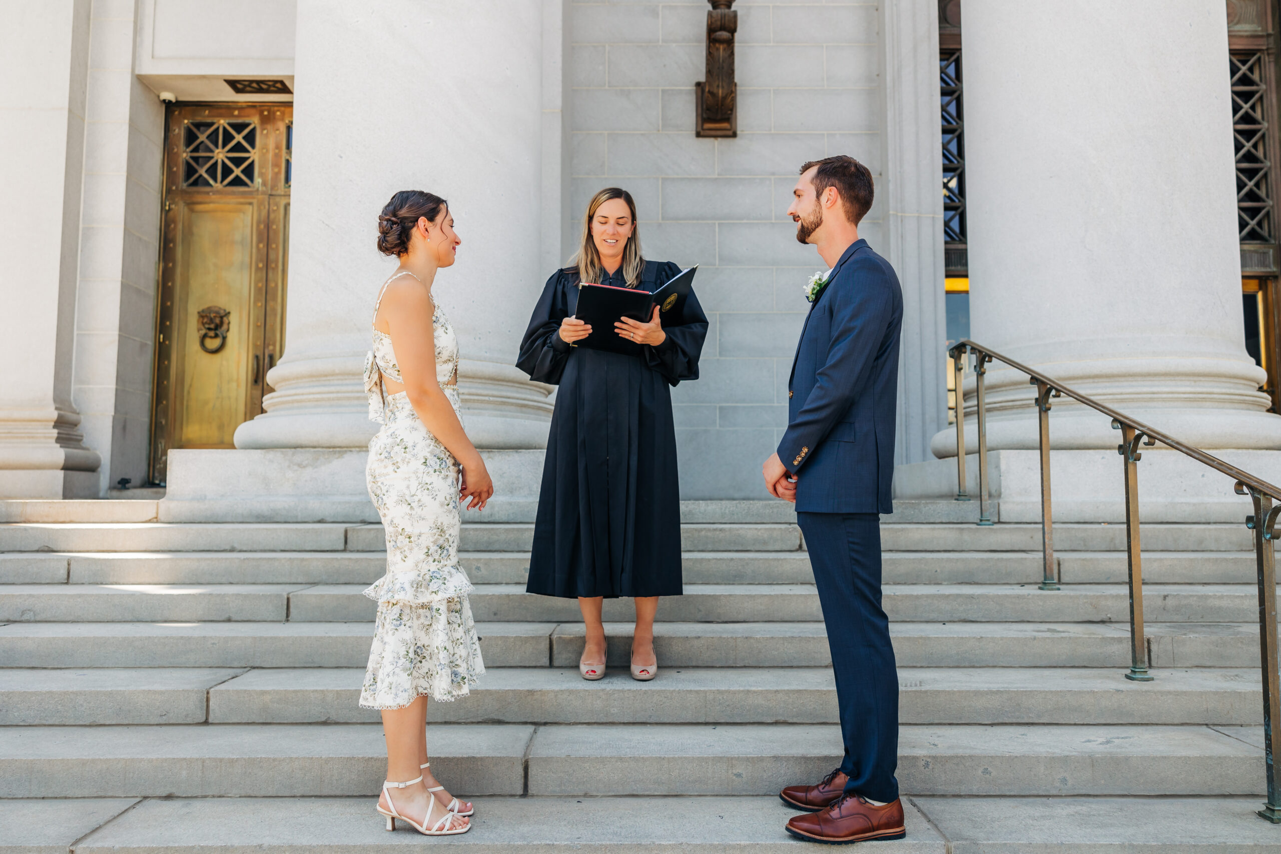 Colorado Elopement Photographer captures bride and groom standing at courthouse with officiant during ceremony