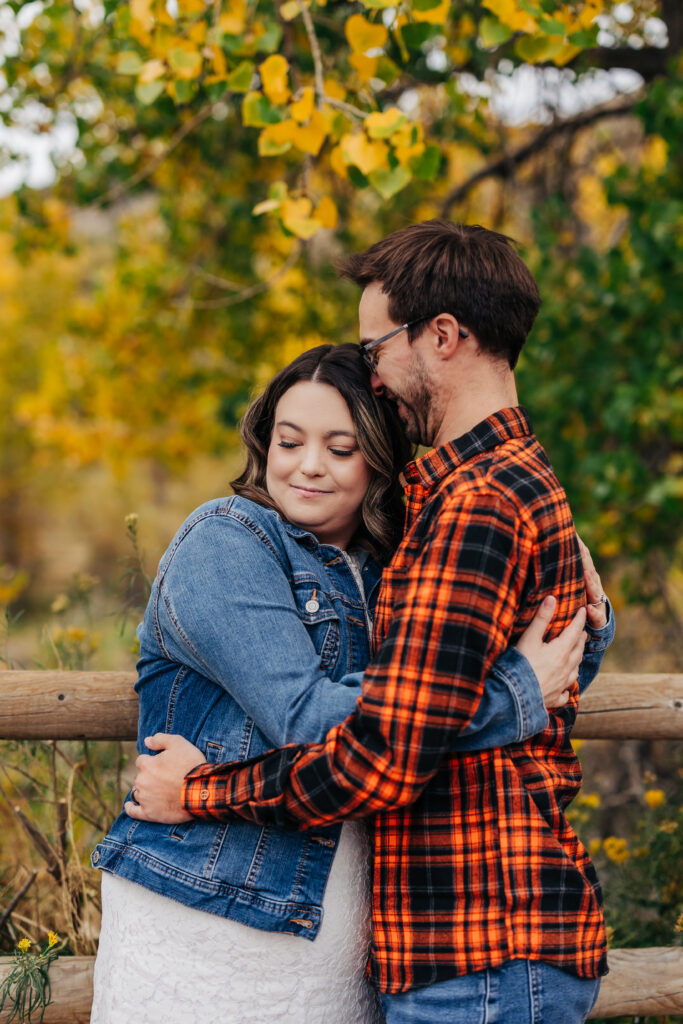 Denver Engagement Photographer captures man hugging woman during fall engagement photos Colorado