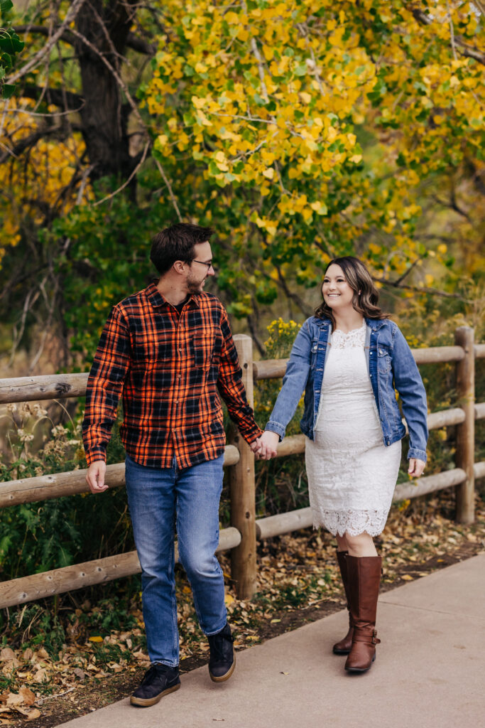 Denver Engagement Photographer captures man and woman holding hands while walking through park