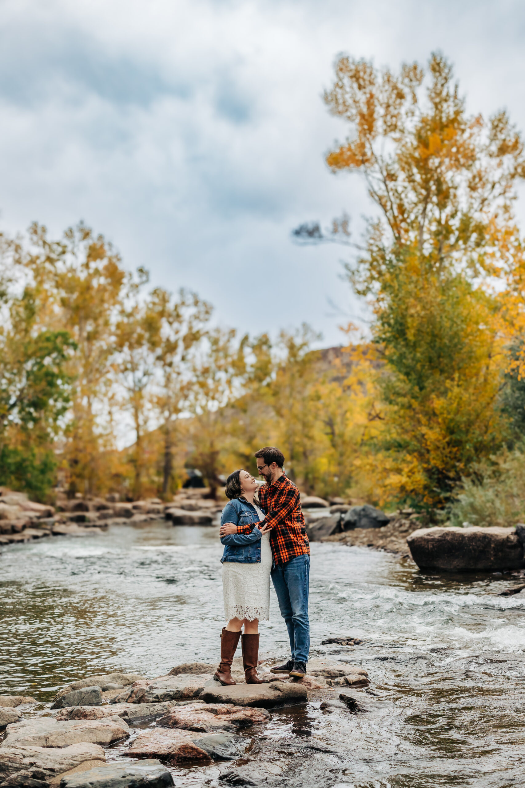 Denver Engagement Photographer captures man and woman in creek during fall engagement photos Colorado