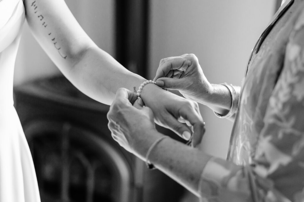 Boulder Wedding Photographer captures mother putting bracelet on bride