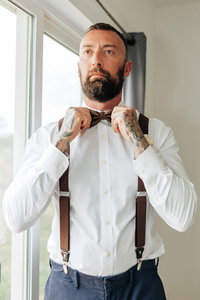 Boulder Wedding Photographer captures groom adjusting bowtie before wedding