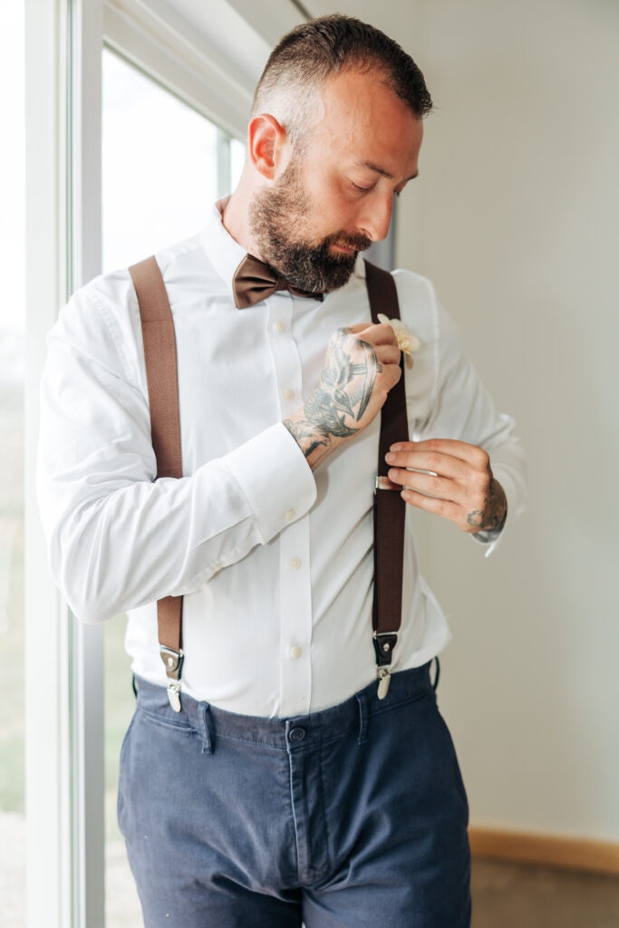 Boulder Wedding Photographer captures groom adjusting suspenders