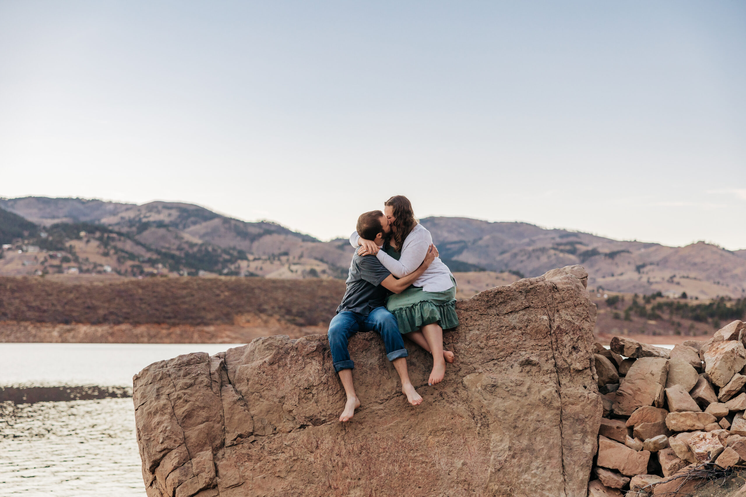 couple sitting on rock in place that feels like them after reading tips for engagement sessions