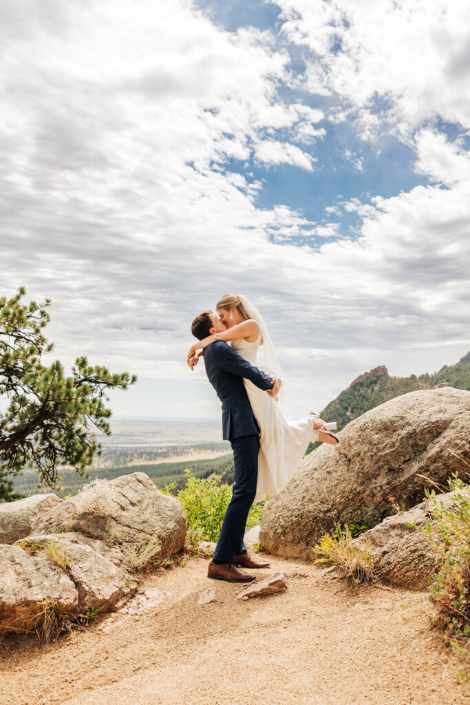 Boulder Wedding Photographer captures groom lifting bride in air and kissing her