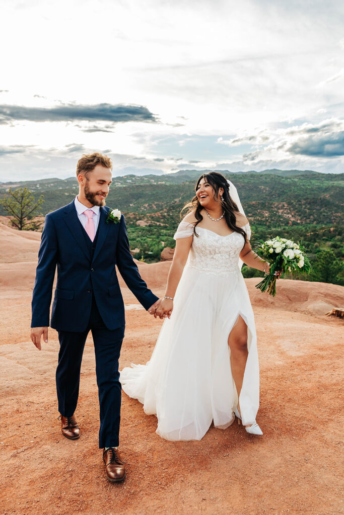 Colorado Elopement Photographer captures bride and groom holding hands on boulder