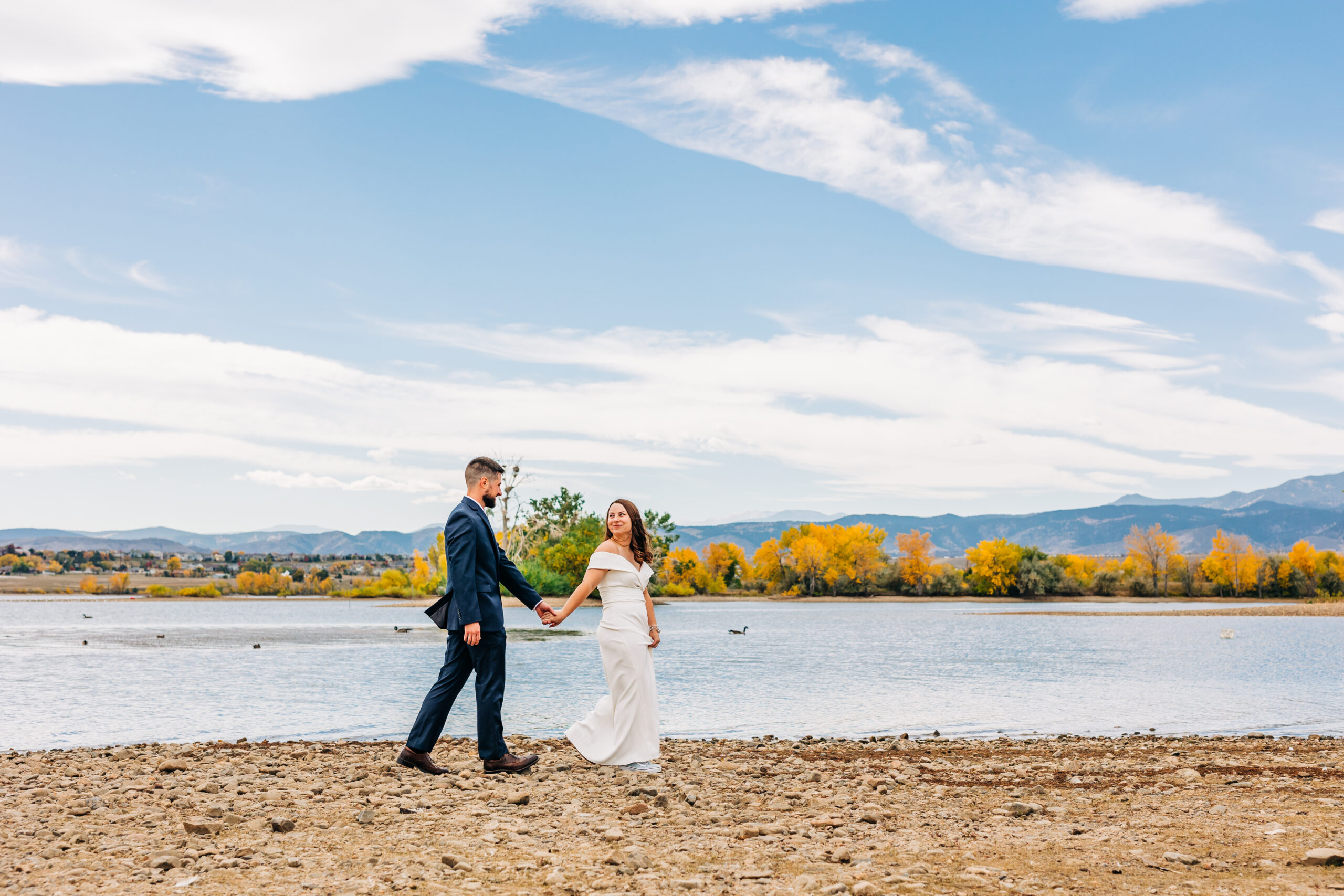 Boulder Wedding Photographer captures bride and groom holding hands and walking together