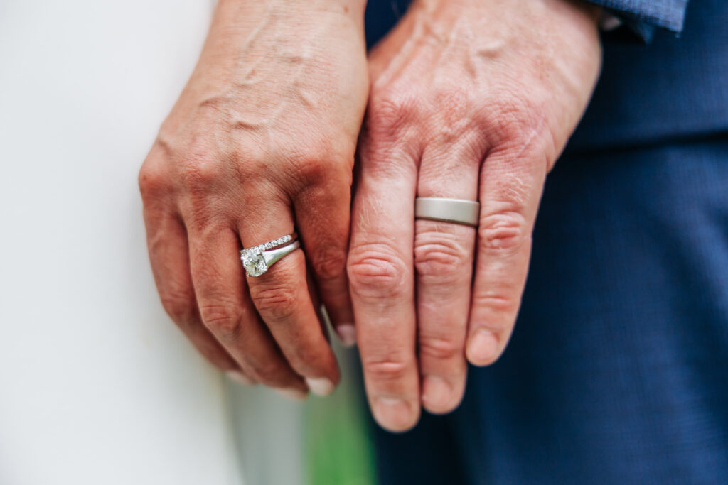 Boulder Wedding Photographer captures bride and groom's hands showing wedding rings