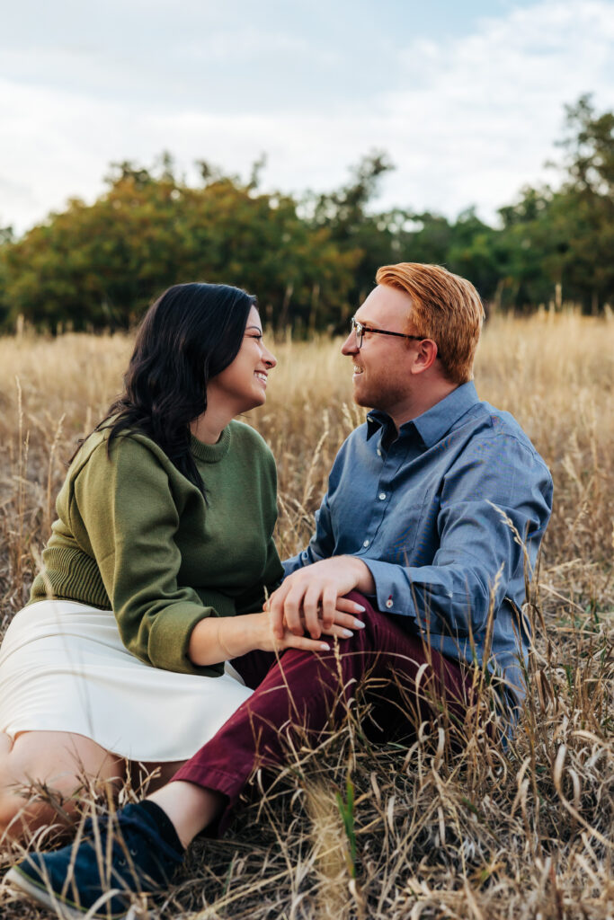 Colorado Elopement Photographer captures couple laughing together during outdoor fall engagement photos in grass