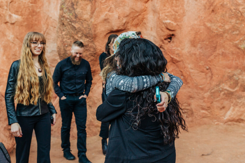 Denver Wedding Photographer captures friends hugging newly engaged couple