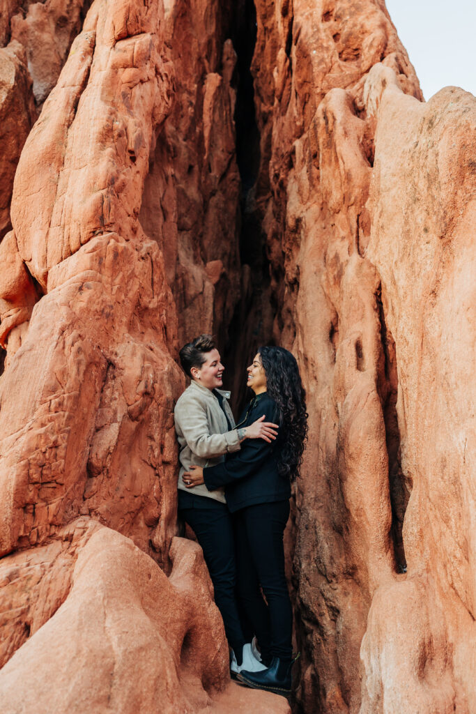 Denver Wedding Photographer captures couple embracing in between red rocks