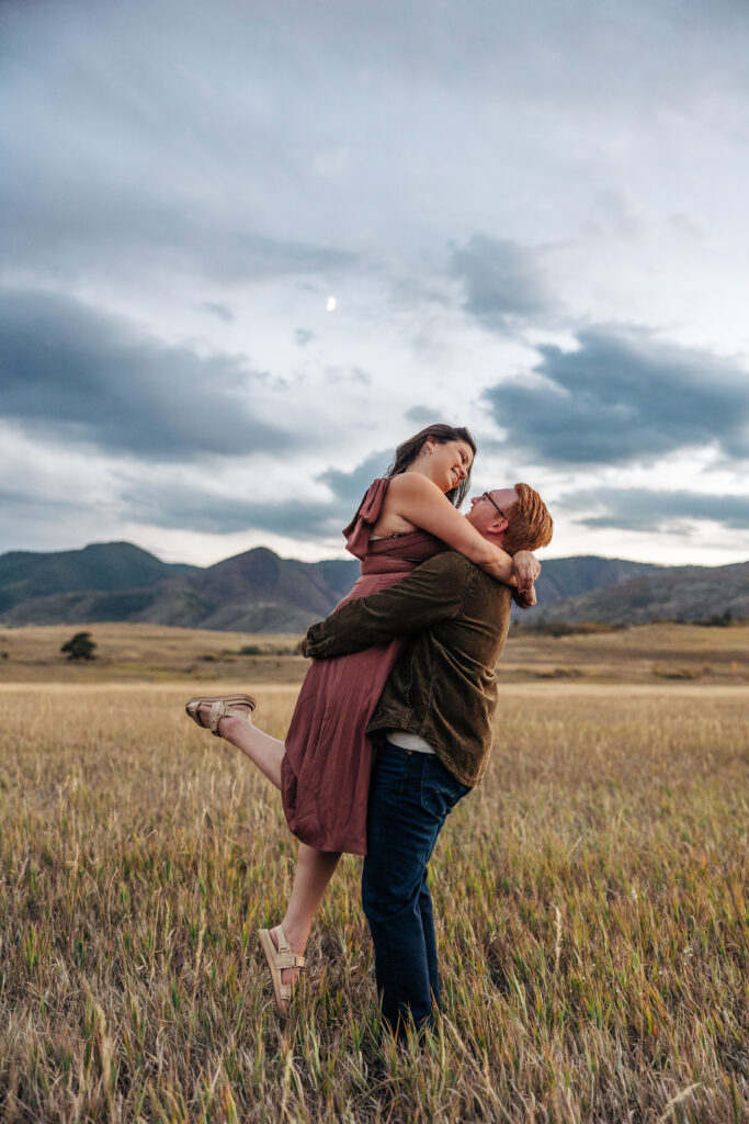 Colorado Elopement Photographer captures man lifting woman in air during fall engagement photos