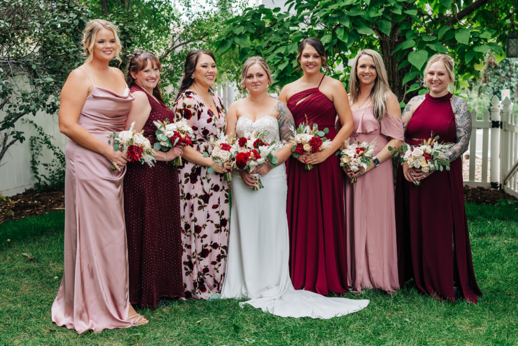 Colorado Elopement Photographer captures bride with bridesmaids wearing pink and burgundy dresses