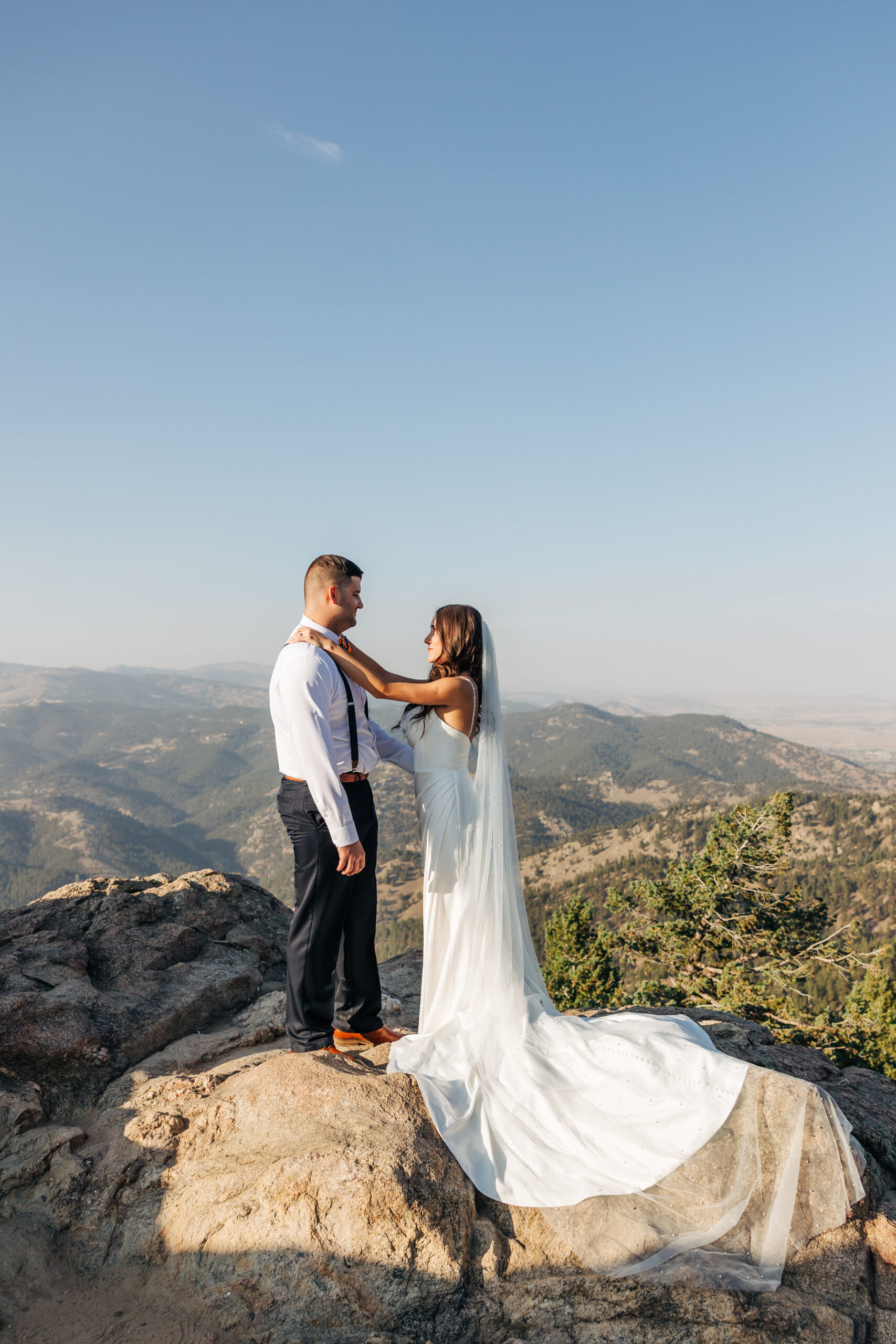 Couple standing together on a rocky peak, taking in the view after saying “I do” in the Colorado high country.