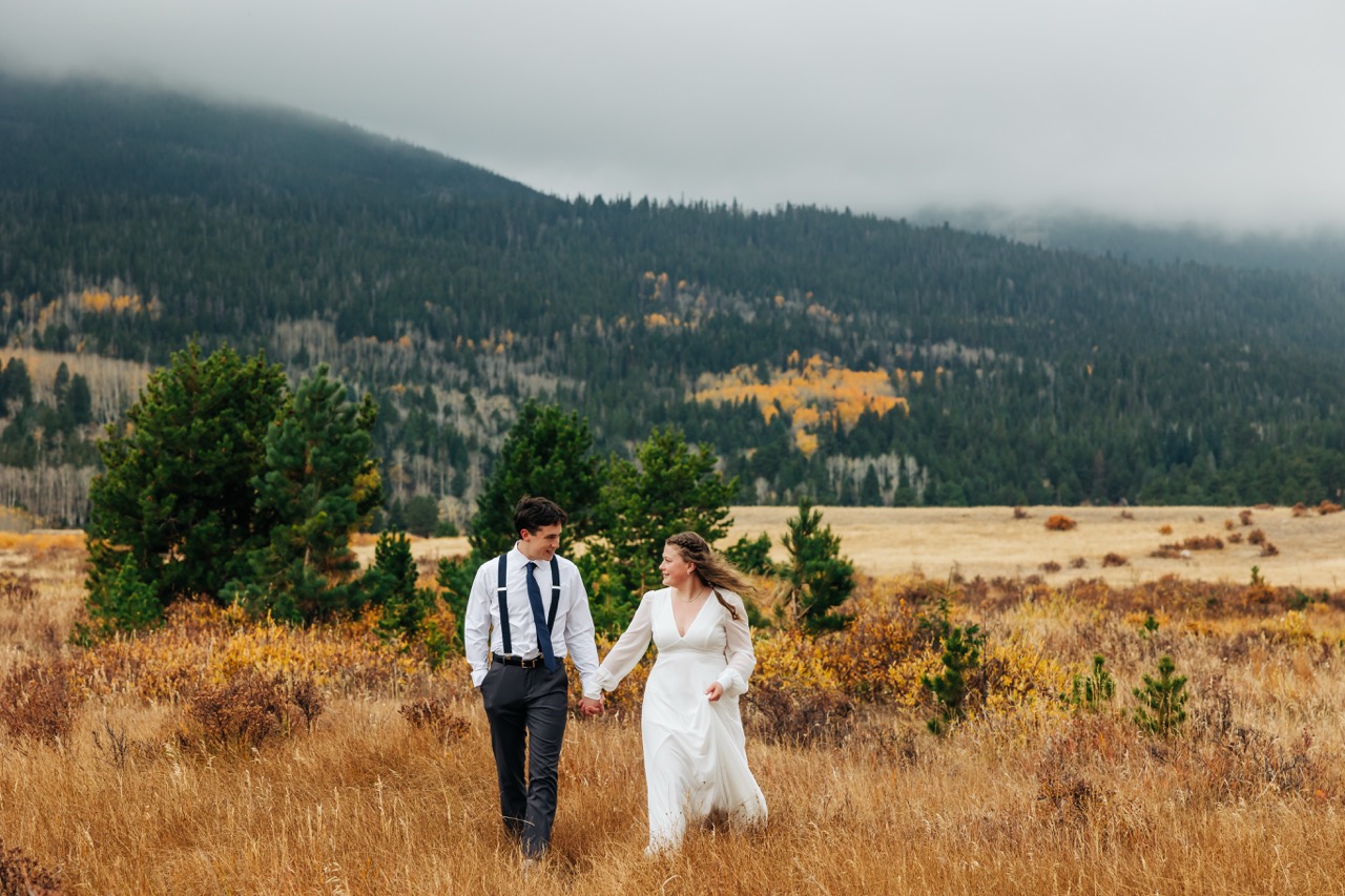 Newlyweds walk through a high-alpine meadow surrounded by fall color in Boulder.
Signing the marriage license on a picnic table in the forest