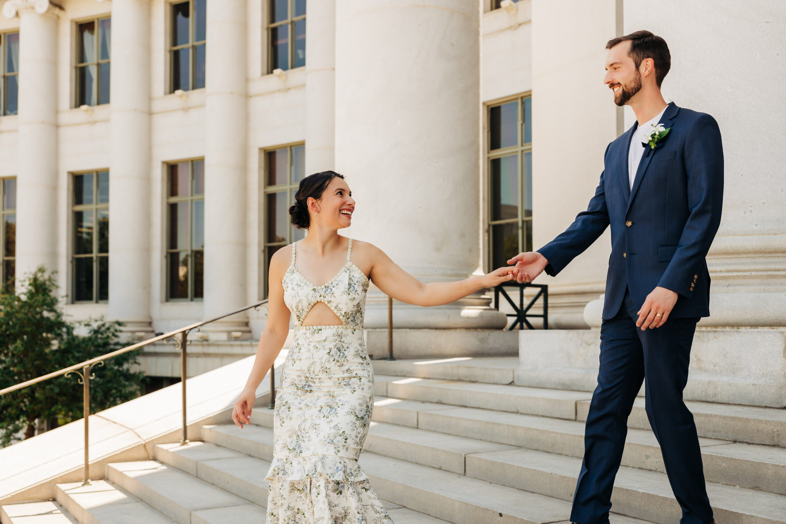 Couple walks down the steps together after saying “I do” at a simple, budget-conscious Colorado courthouse wedding.