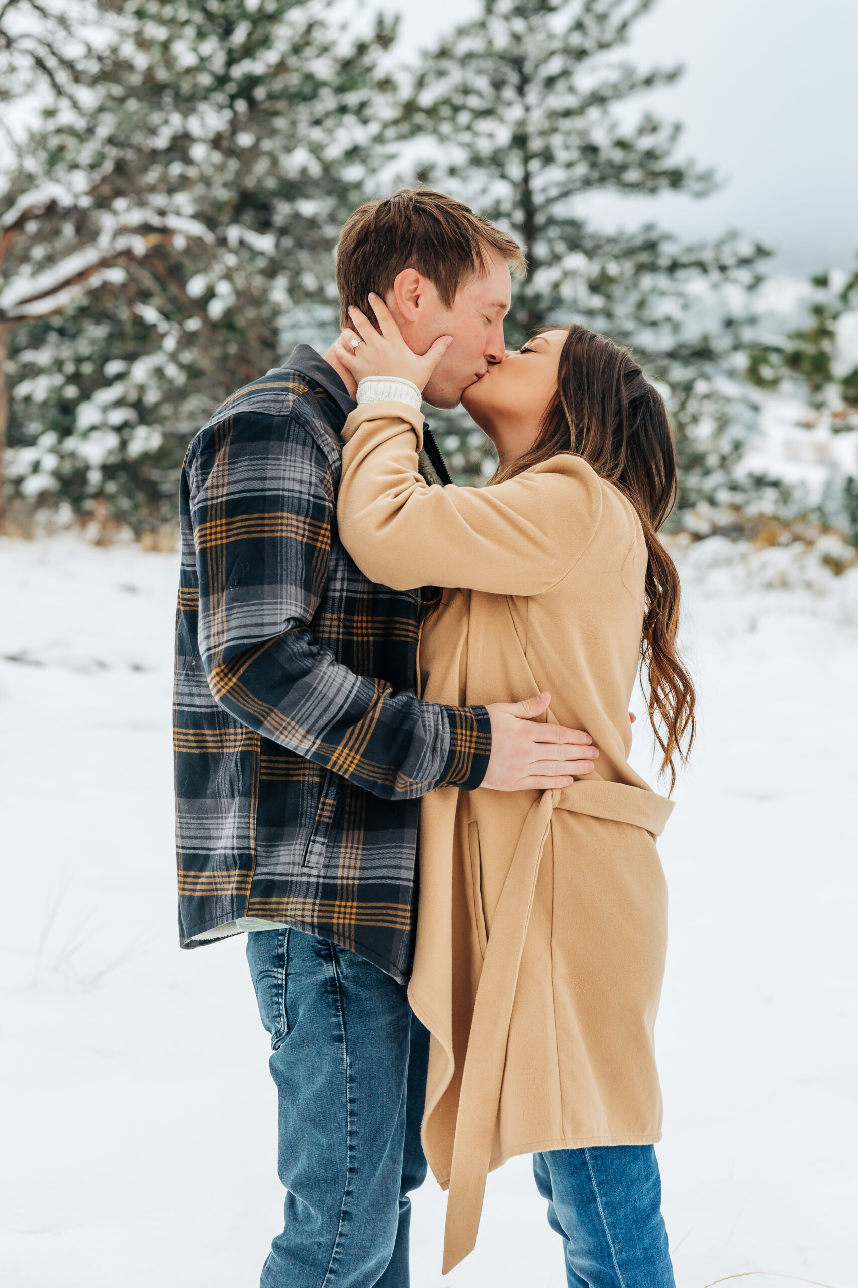 A heartfelt winter kiss with pine trees and fresh snow, bringing all the mountain romance to these Boulder engagement photos.